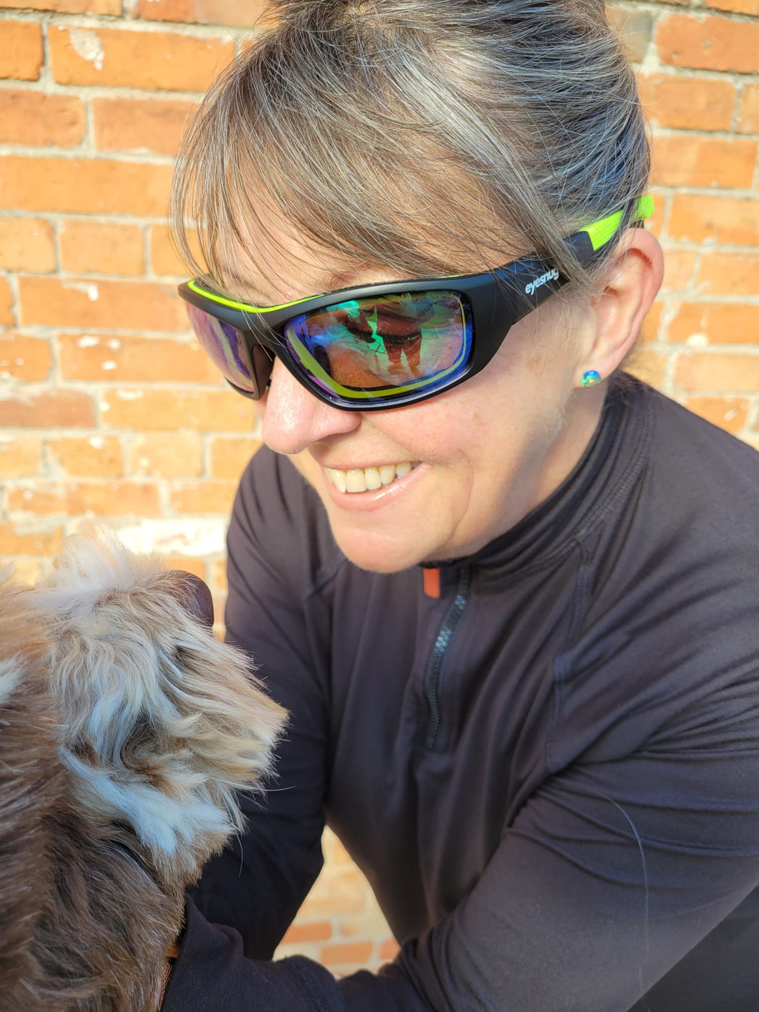 Woman wearing close-fit black and lime Eyesnug wraparound sunglasses