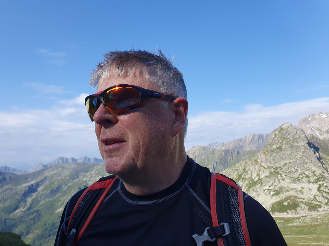 Trail runner wearing Eyesnug Pursuit wraparound sunglasses on a mountain ridge
