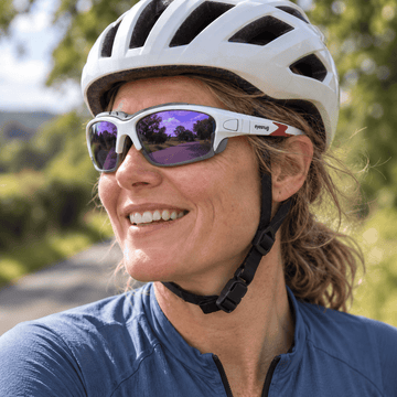 Cyclist in navy jersey wearing Eyesnug sunglasses outdoors.